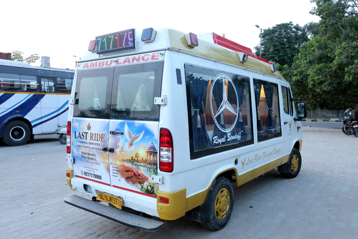 Last Ride Funeral AC glass hearse van rear/side profile showing full LRF livery, dove emblem, and 9217179989 helpline — Delhi NCR 24x7 dispatch