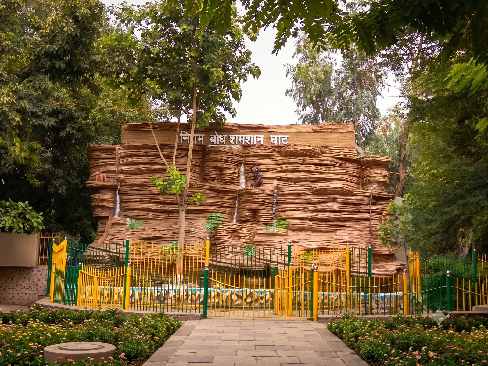 Entrance monument of Nigam Bodh Shamshan Ghat with Devanagari signage निगम बोध शमशान घाट, walkway and flower beds in Civil Lines, Delhi